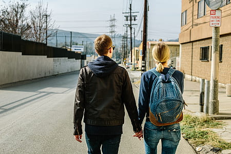 man and woman standing on side of street holding hands thumbnail