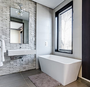 white ceramic bathtub beside window thumbnail