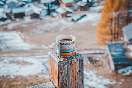 blue and orange striped mug filled with coffee on brown panel thumbnail