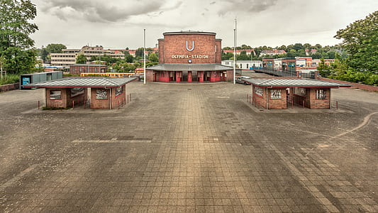 brown concrete building on pavement under gray cloudy sky at daytime thumbnail
