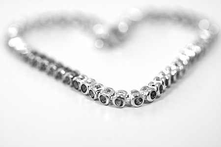 silver bracelet in heart shape on white surface thumbnail