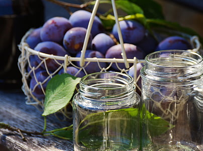 bunch of purple fruits near on two glass mason jars thumbnail