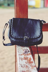 black leather crossbody bag on handrail thumbnail