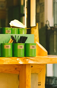 Six Green Tin Can Containers on Table thumbnail