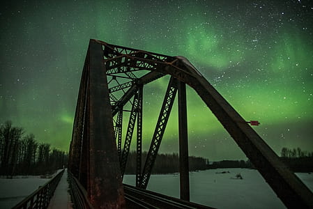 photography of bridge during green sky phenomenon thumbnail
