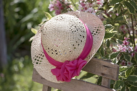 women's pink and white hat on brown chair thumbnail