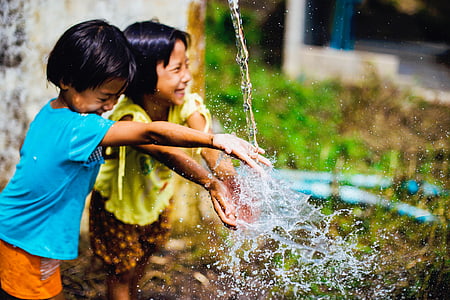 children playing water near gray wall thumbnail
