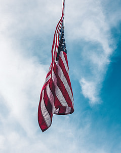 low-angle photography of flag of America under cloudy sky thumbnail