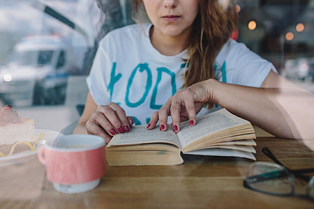 Woman reading book at coffee shop thumbnail