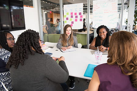Women Sitting Beside White Wooden Table thumbnail