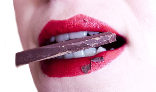 woman with red lipstick biting black chocolate thumbnail