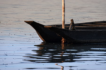 bamboo stick between two canoes on body of water thumbnail