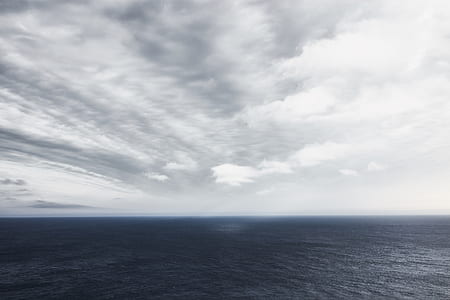 body of water under cloudy sky during daytime thumbnail