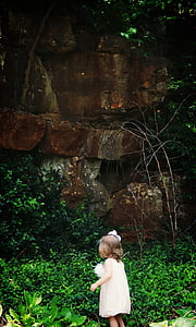girl standing beside green plants thumbnail
