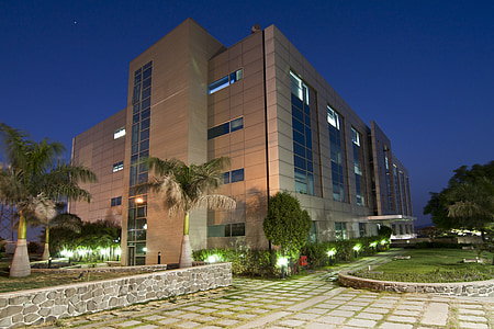 brown concrete building near trees and plant thumbnail