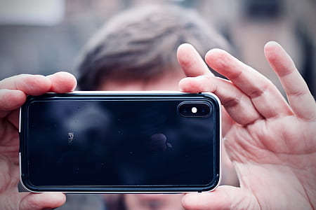 person holding black space gray iPhone X thumbnail