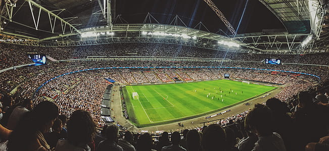 green football field surrounded by people during nighttime thumbnail