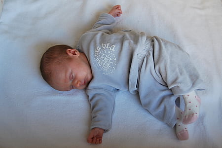 baby sleeping on white sheet thumbnail
