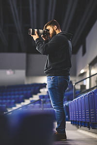 photo of man using DSLR camera with telephoto lens thumbnail