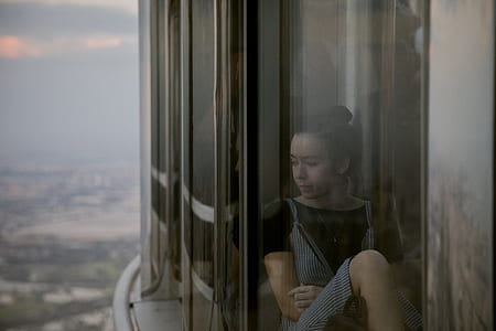 woman sitting on glass window thumbnail