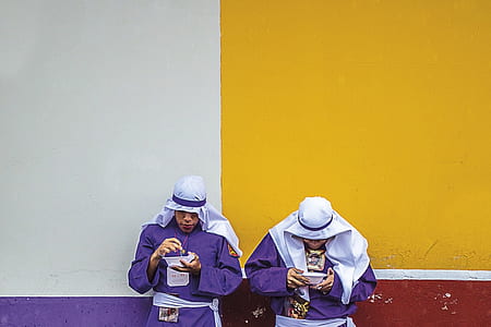 two men leaning on wall holding bowls thumbnail