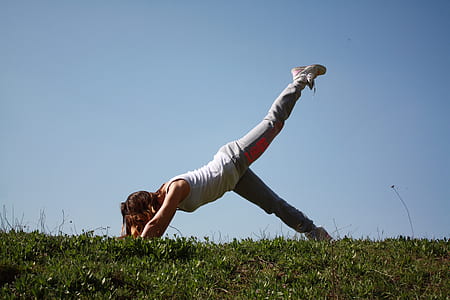woman bending on green field thumbnail