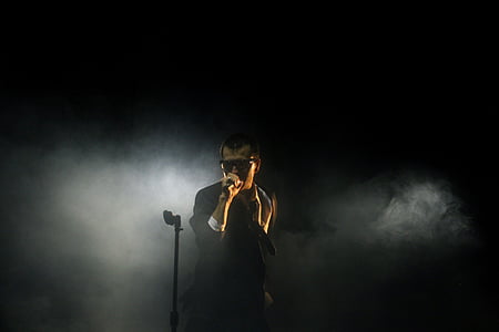 man wearing black suit holding microphone thumbnail