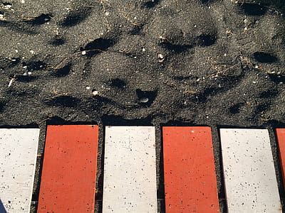 Red and White Metal Planks on Black Sand thumbnail