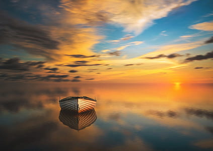 brown canoe on calm body of water during golden hour thumbnail