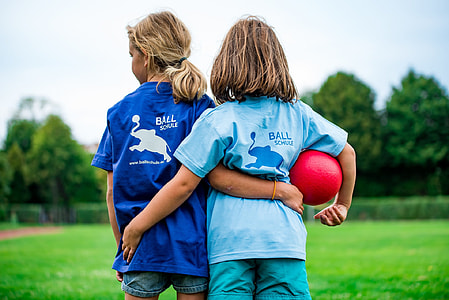 two girl in blue top standing on grass lawn during daytime shallow focus photography thumbnail