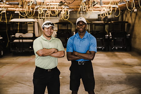 Two Men Crossing Arms While Standing Near Golf Carts thumbnail