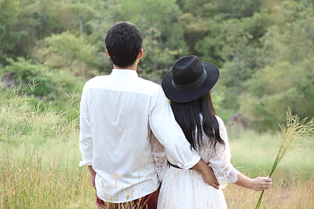 man and woman standing on grass field at daytime thumbnail