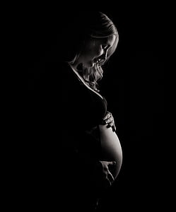 grayscale photo of pregnant woman touching her belly thumbnail