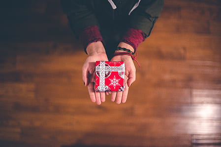 person holds red and white gift box thumbnail