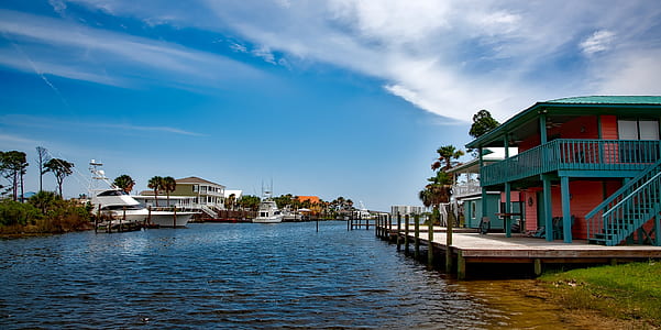 blue and red house near body of water thumbnail