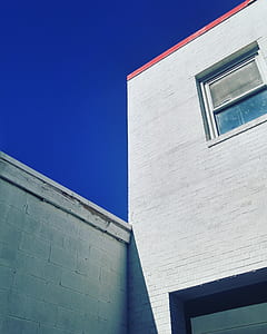 white concrete house with glass window under blue sky thumbnail