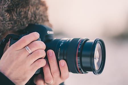 person capturing image using black Canon DSLR camera thumbnail