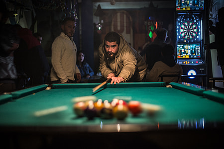 man wears brown leather zip-up jacket playing billiard thumbnail