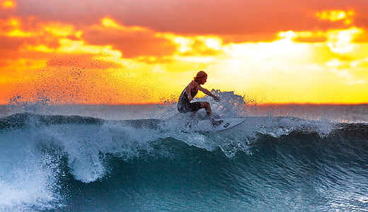 woman surfing during sunset thumbnail
