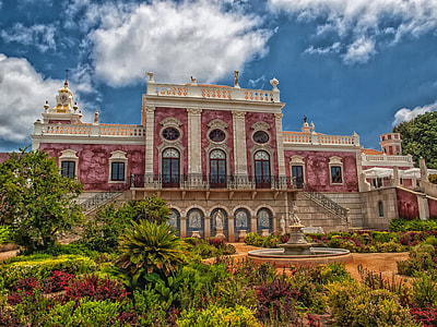 photo of a red and brown castle near garden and fountain thumbnail
