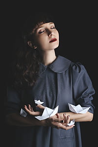 woman holding four shirt paper boats thumbnail