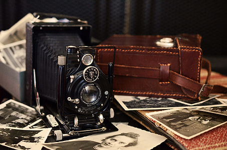vintage camera beside leather bag thumbnail