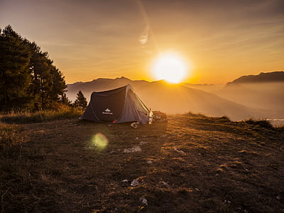 outdoor tent on the peak of the mountain near tree during sunset thumbnail