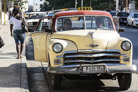 two men inside taxicab beside sidewalk near vehicles during day thumbnail