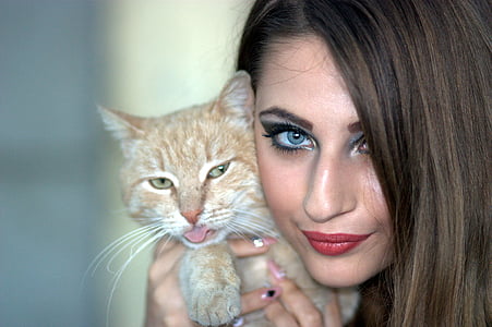 woman carrying orange tabby cat thumbnail