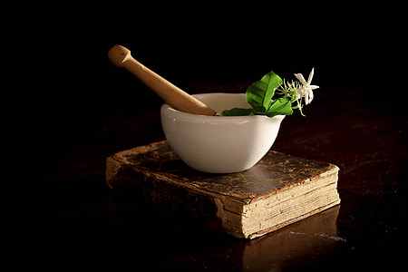 white and brown mortar and pestle on brown book thumbnail