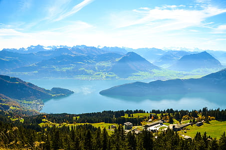 top view of mountain showing body of water in middle under cloudy sky thumbnail