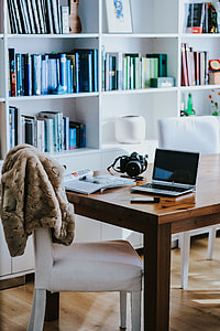 Silver laptop with various items on a table thumbnail