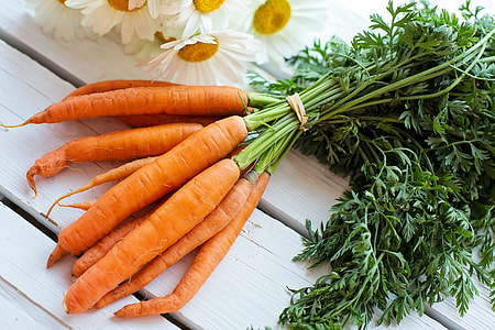 bunch of carrots and hers on white wooden board thumbnail