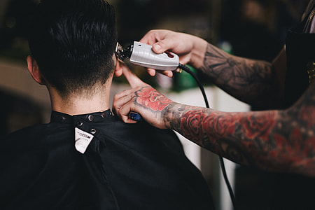 person trimming hair of man thumbnail